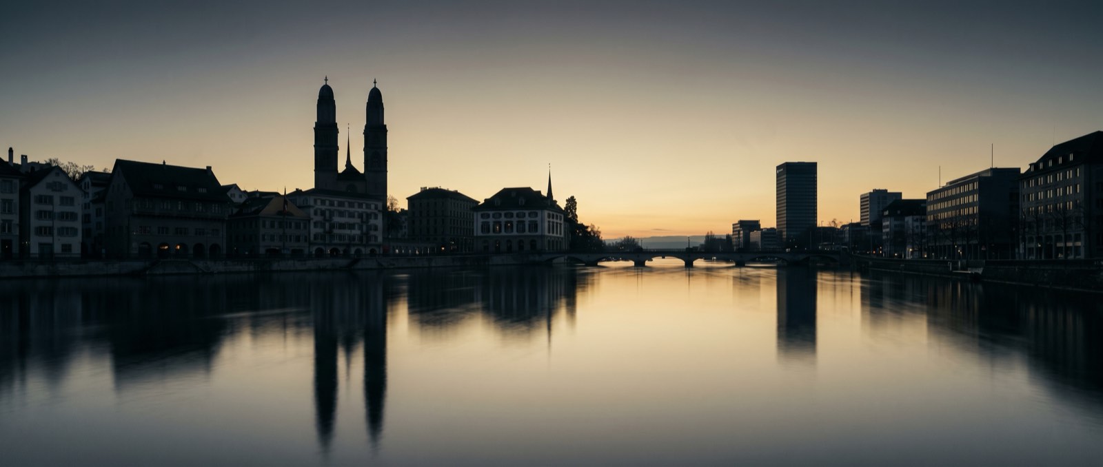 Zurich skyline at dawn – Limmat, gold sky, graphite silhouettes